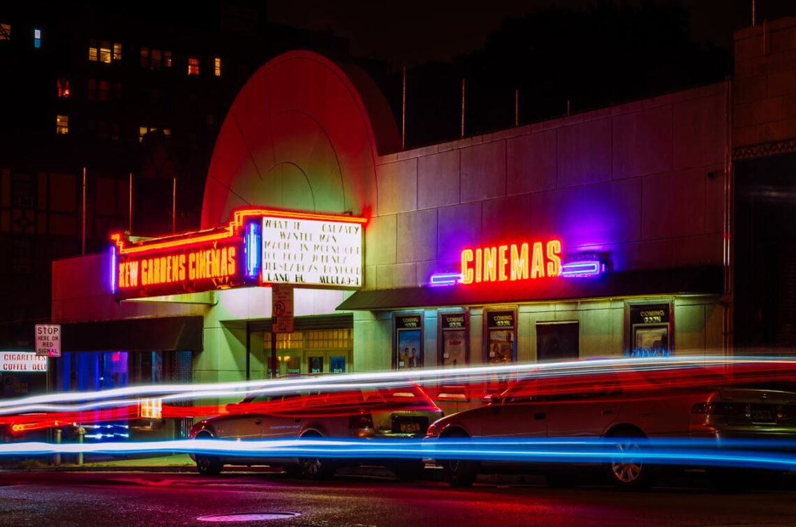 Image is the outside of a movie theater at night