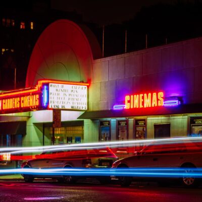 Image is the outside of a movie theater at night